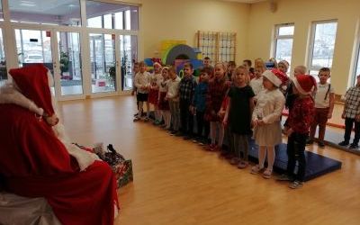 Grupa Żyrafki podczas spotkania z Mikołajem. Dzieci śpiewają piosenkę przygotowaną dla Mikołaja.