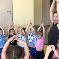 Dzieci wraz z Panią ćwiczą jogę.