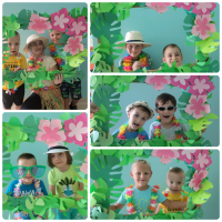 Grupa chłopców wraz z wychowawcą pozuje do zdjęcia w zielonej ramce z liści.