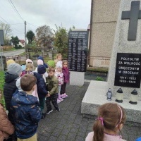 Dzieci stoją przed pomnikiem 