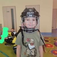Chłopiec przymerza kask hokejowy.