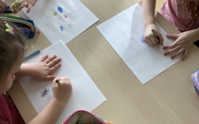 Przedszkolaki kolorują obrazek przedstawiający wirusy.