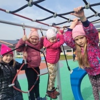 Grupa dziewczynek bawi się na placu zabaw.