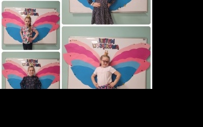 Dziewczynki pozują do zdjęcia z kolorowymi skrzydłami.