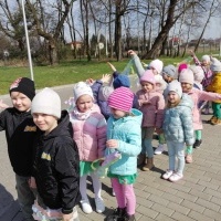 Dzieci, parami z kolorowymi szarfami idą szukać wiosny.