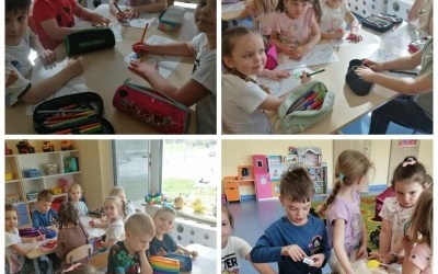 Dzieci siedzą przy stolikach i kolorują kartę pracy.