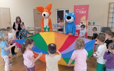 Dzieci wraz z bohaterami Fenkiem i Maksiem bawią się chustą animacyjną