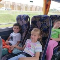 Dzieci siedzą w autobusie. Jadą na wycieczkę. 