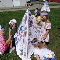 Dzieci malują farbami wigwam grupy Kotki.